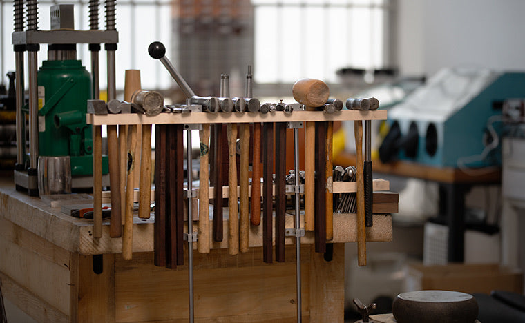 Jeweler’s tool wall with hammers used for hand-texturing silver and gold in a small studio.