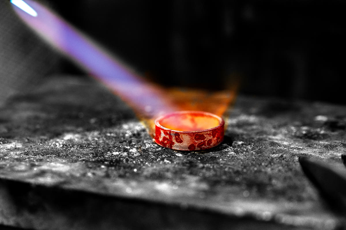 Textured ring being heated on a jewelry workbench at YophieMade.