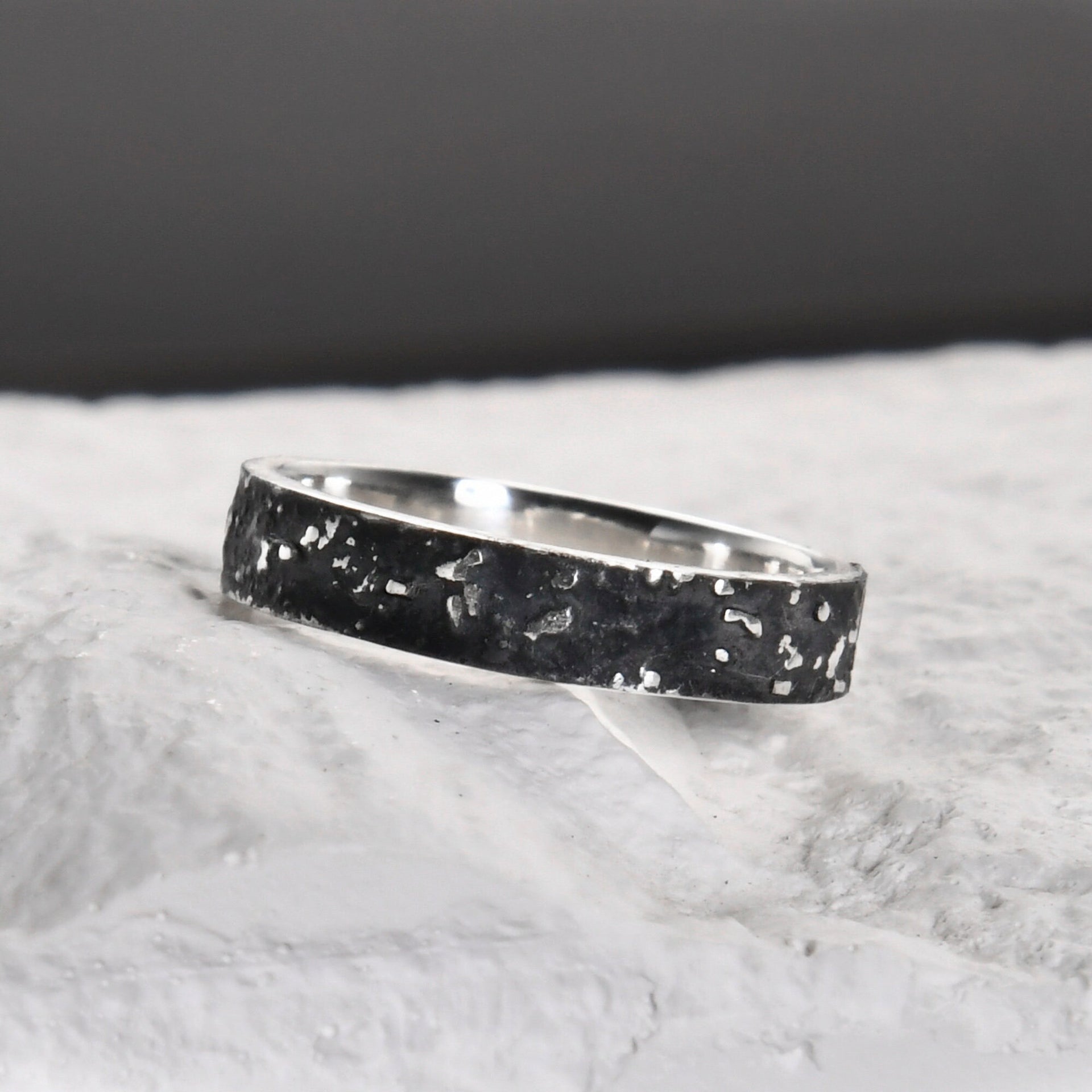 Close-up of the slim 4mm silver band with dark fused lava and galaxy texture.