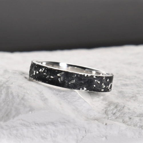 Close-up of the slim 4mm silver band with dark fused lava and galaxy texture.