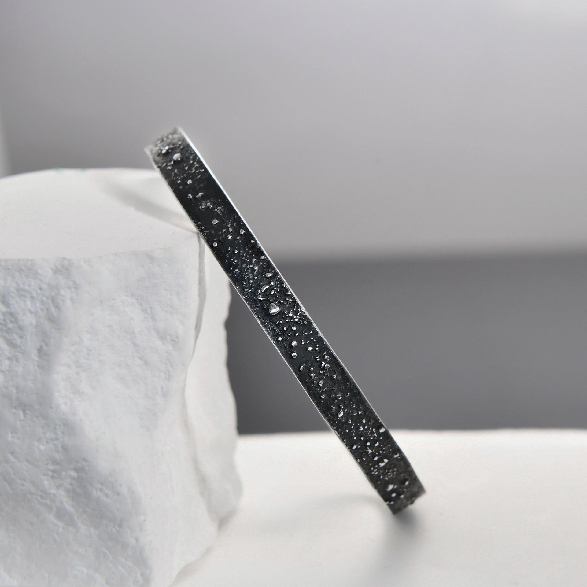 Slim adjustable gunmetal grey cuff bracelet with engraved stars