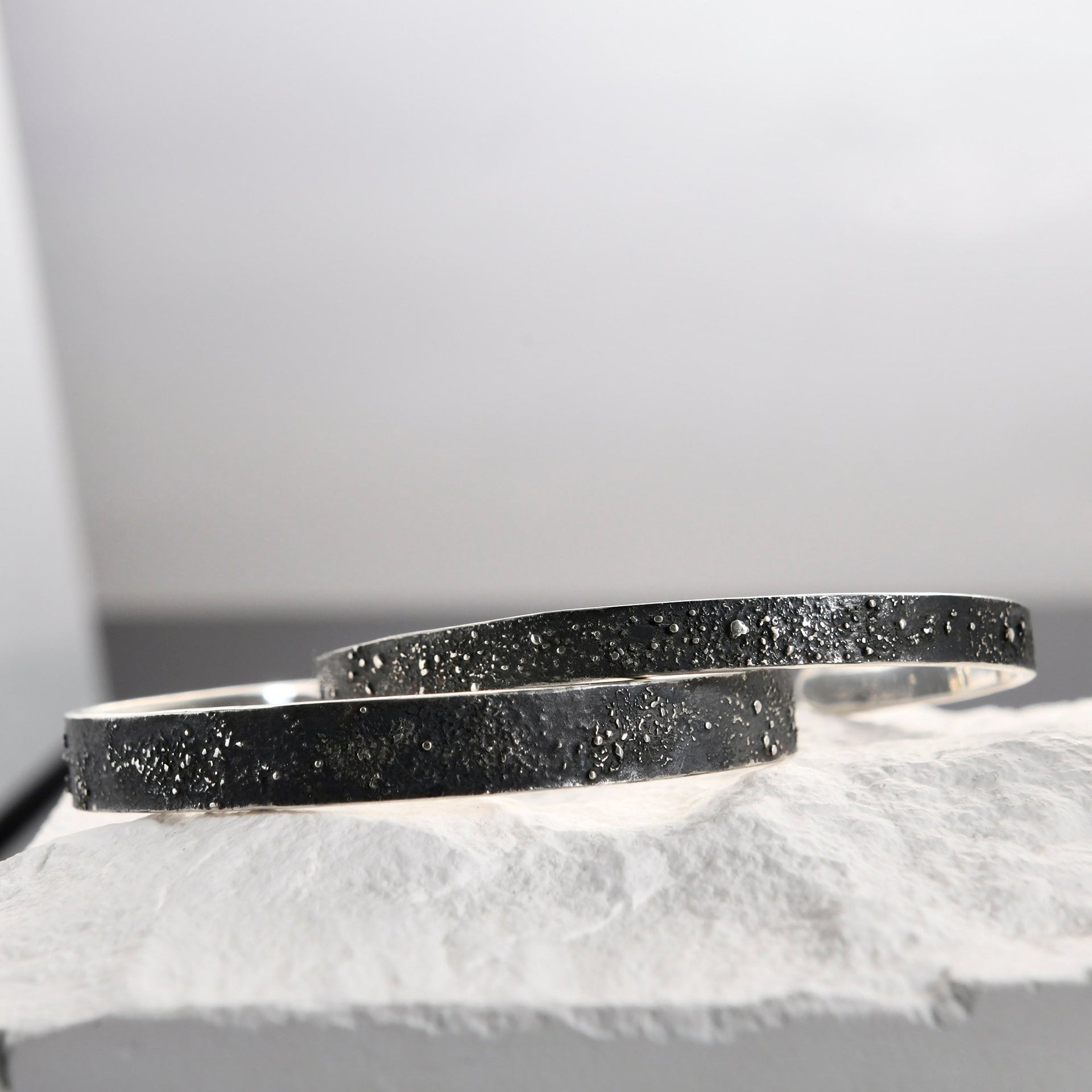 Gunmetal grey open cuff bracelet with engraved night sky design