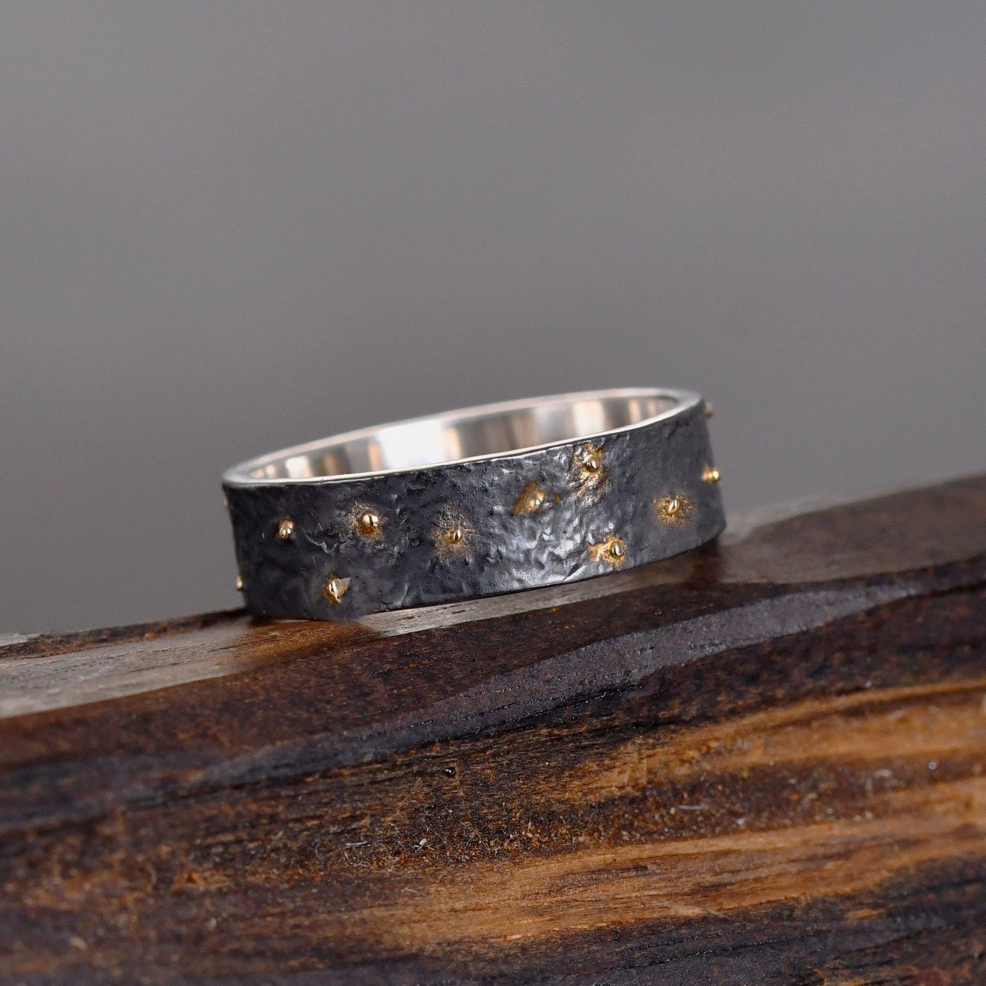 Solid 18K gold star accents fused into an oxidized silver band