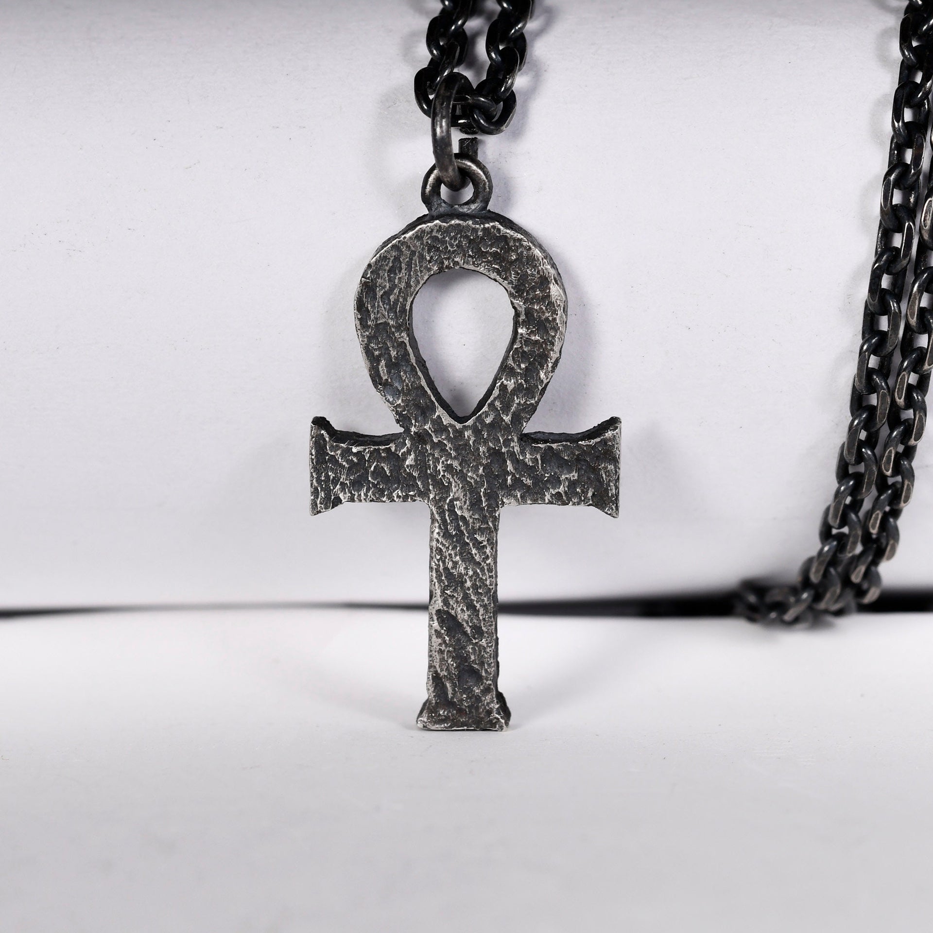 Close up of oxidized ankh pendant with rustic silver surface