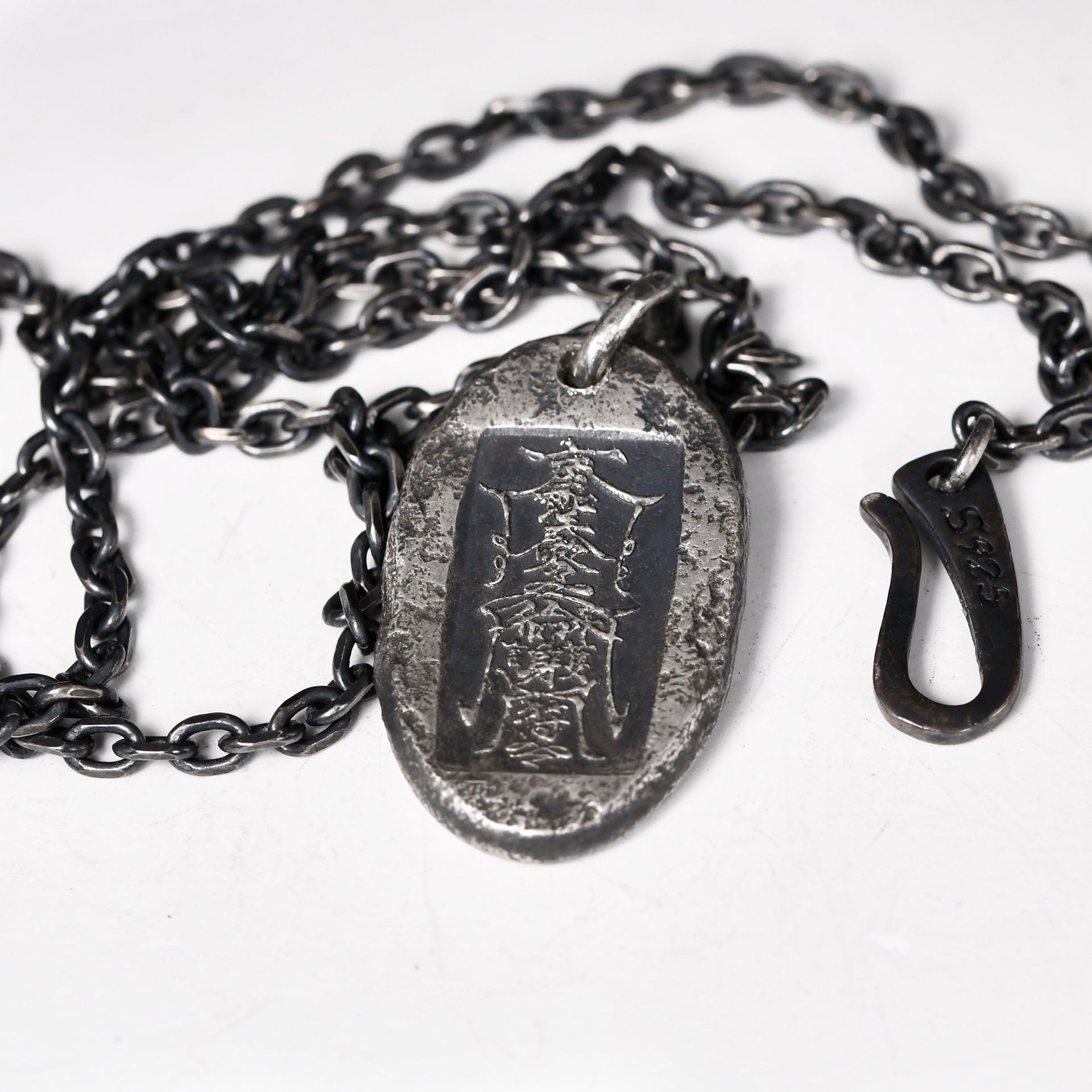 Oxidized sterling silver talisman pendant worn as symbolic jewelry