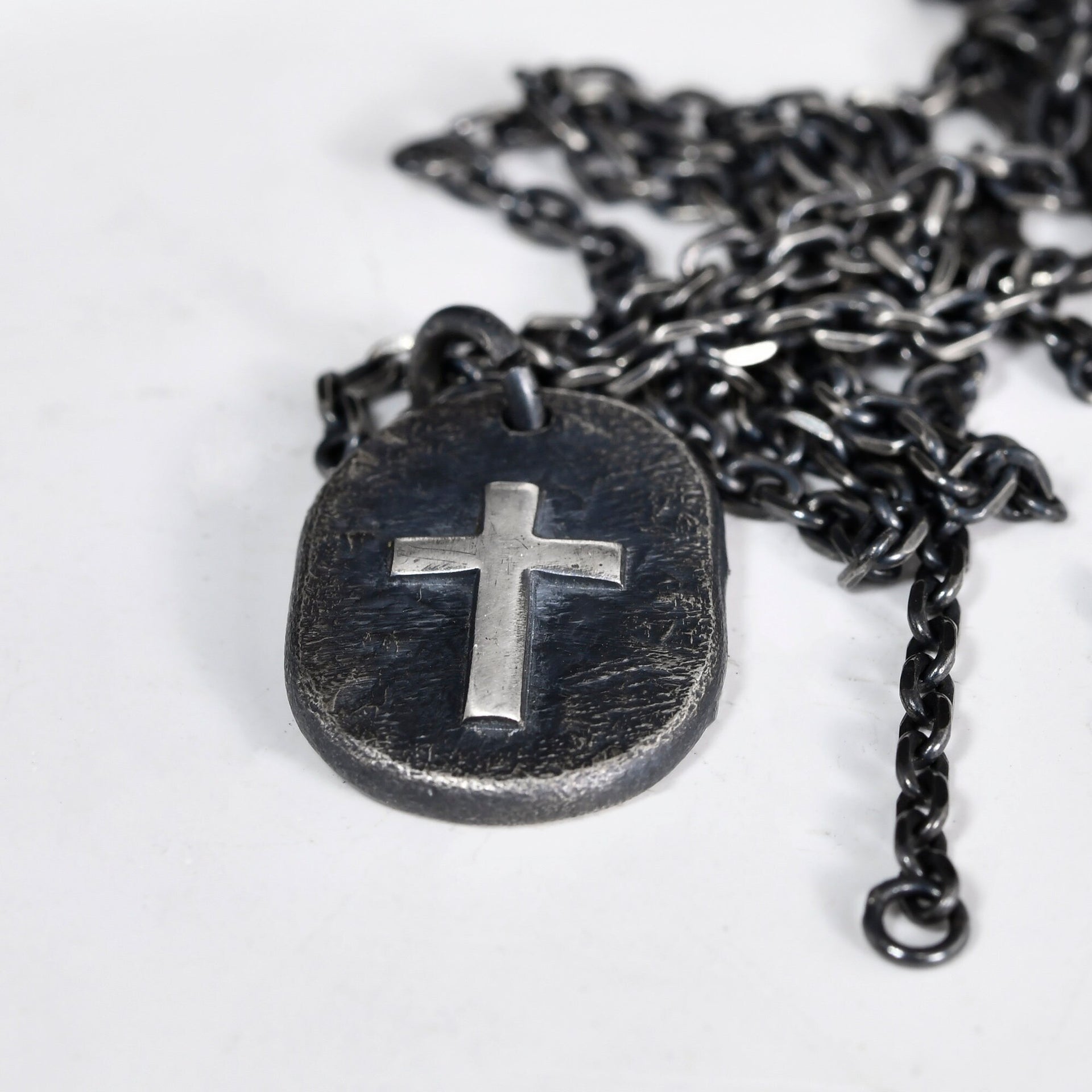 Rustic handmade cross pendant with dark oxidized surface and bright edges