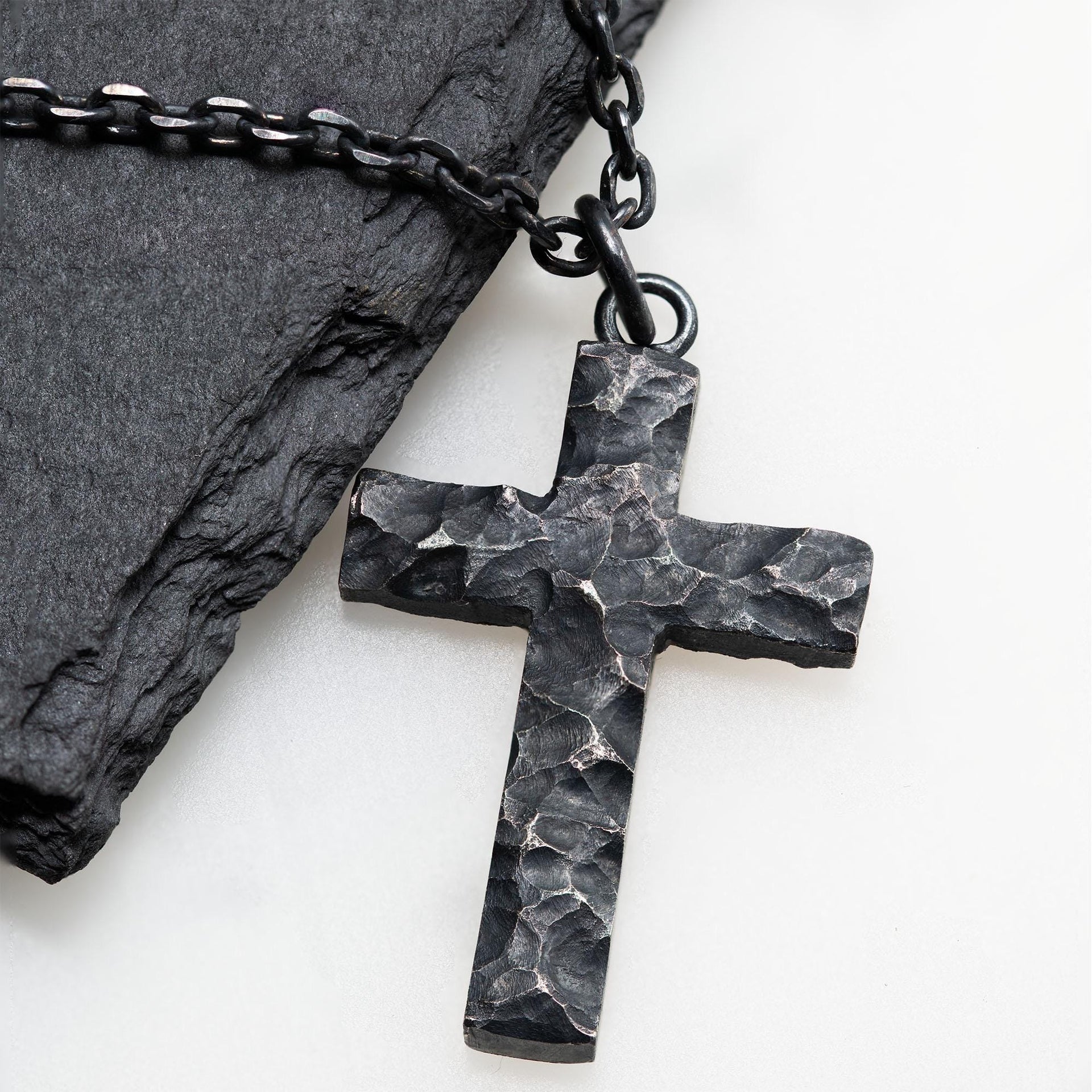 Black rock texture cross pendant worn as a meaningful faith necklace