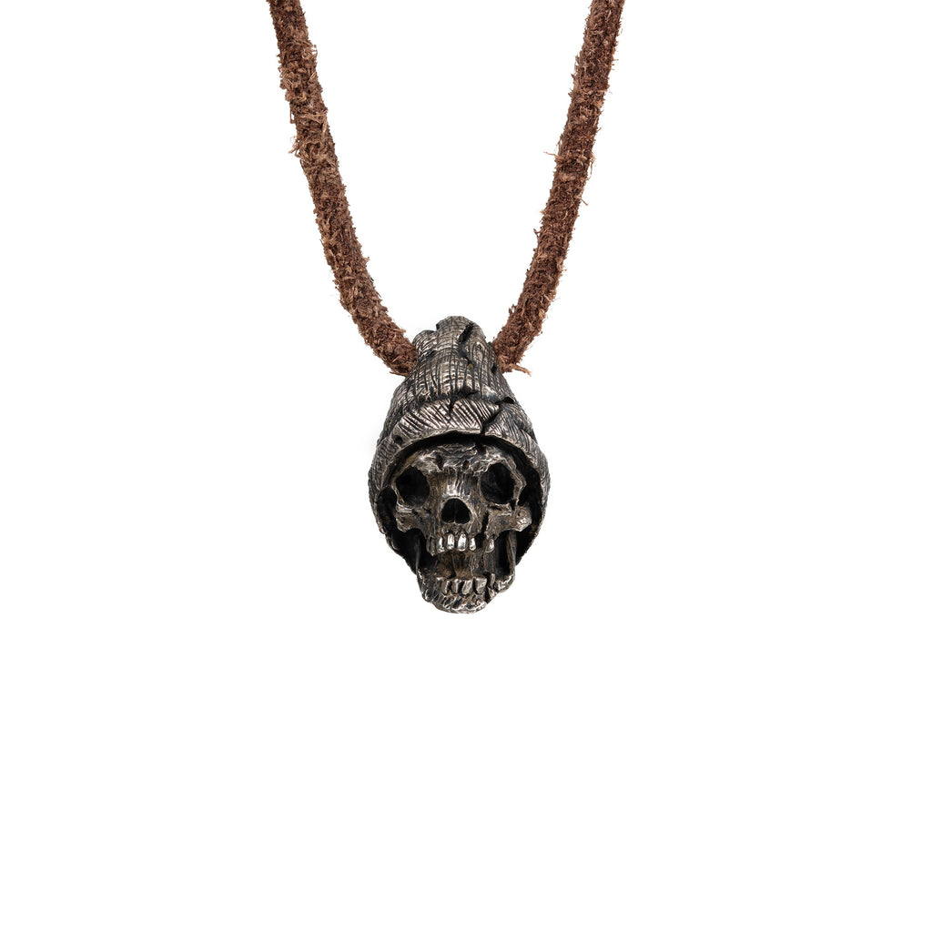 Men's beanie skull necklace in oxidized nickel silver, front view of the hand carved skull pendant in a ribbed knit beanie on a dark brown leather cord, white background