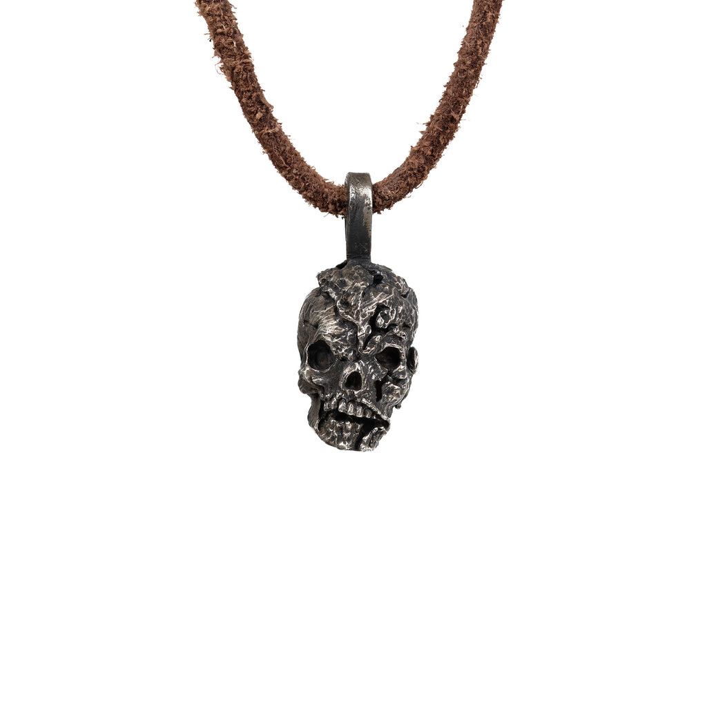 Men's exposed brain skull necklace in oxidized nickel silver, front view of the hand carved skull pendant with an open cranium on a dark brown leather cord, white background