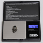 Top hat skull pendant on a digital pocket scale reading 13.70 g, oxidized nickel silver