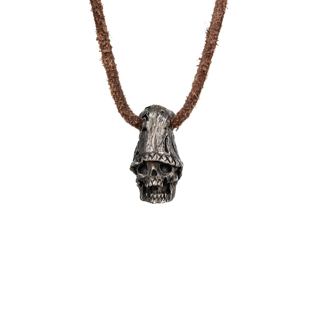 Men's top hat skull necklace in oxidized nickel silver, front view of the hand carved skull pendant on a dark brown leather cord, white background