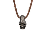 Men's top hat skull necklace in oxidized nickel silver, front view of the hand carved skull pendant on a dark brown leather cord, white background