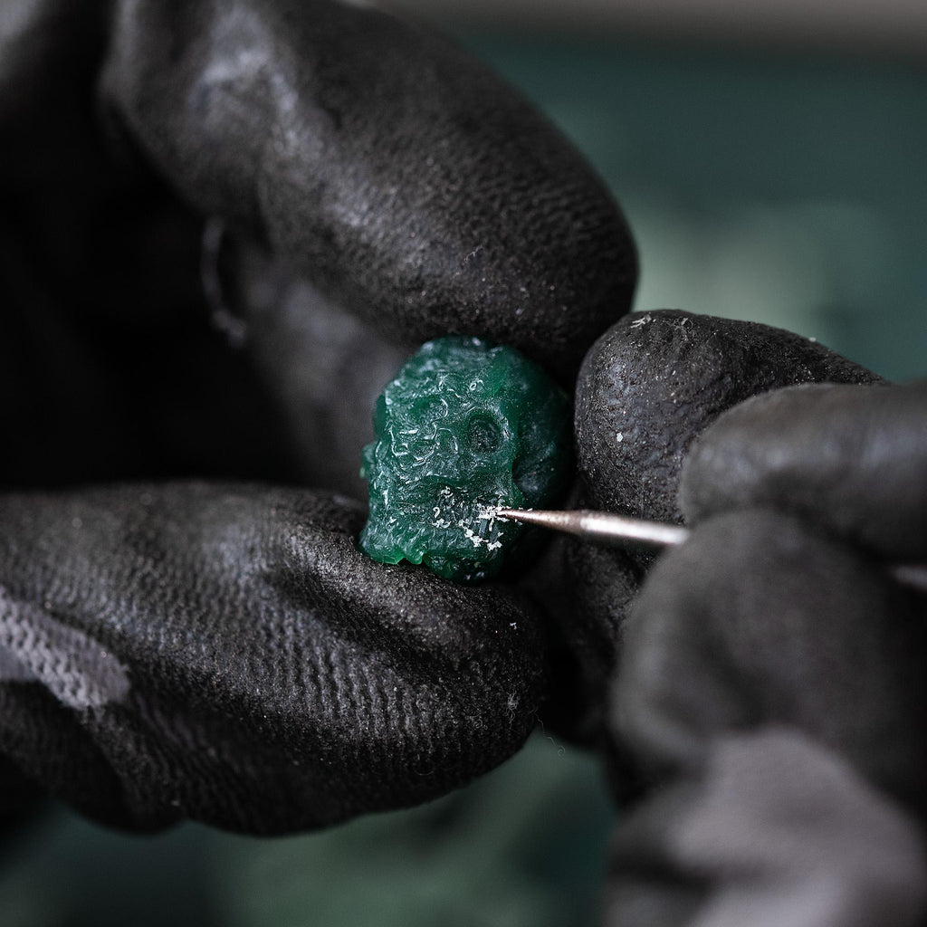 Hand-carved green wax master model of the skull pendant before casting.