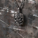 Double-face skull pendant in oxidized 925 sterling silver, lit to show its carved sculptural depth.