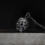 Side view of the oxidized skull pendant showing its depth and carved profile.