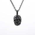 Front view of the double faced skull pendant in oxidized 925 sterling silver on a white background, hanging from a dark chain.