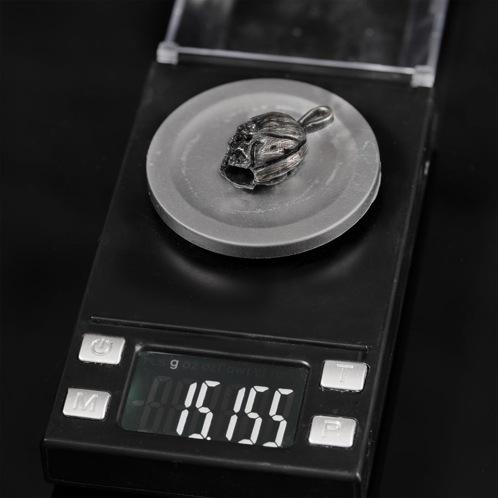Sterling-silver skull pendant on a digital scale reading approximately 15.2 grams.